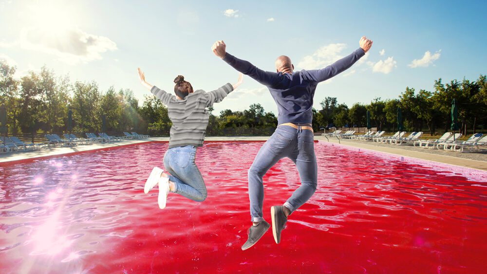Two people jumping into a pool of Kool-Aid